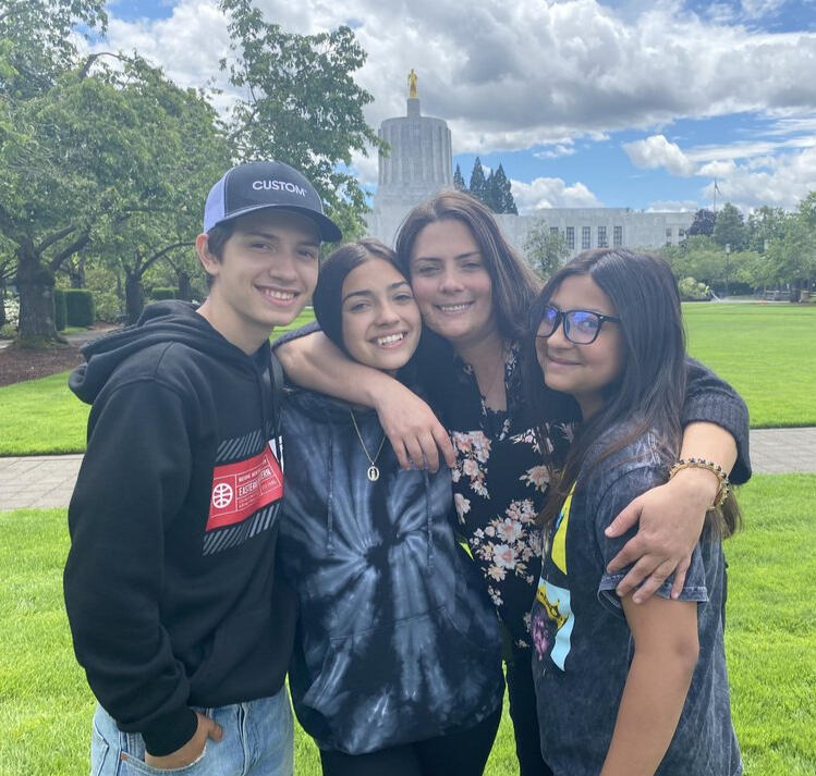 FPP Family Preservation Project Mom hugging her 2 daughters and 1 son standing together.